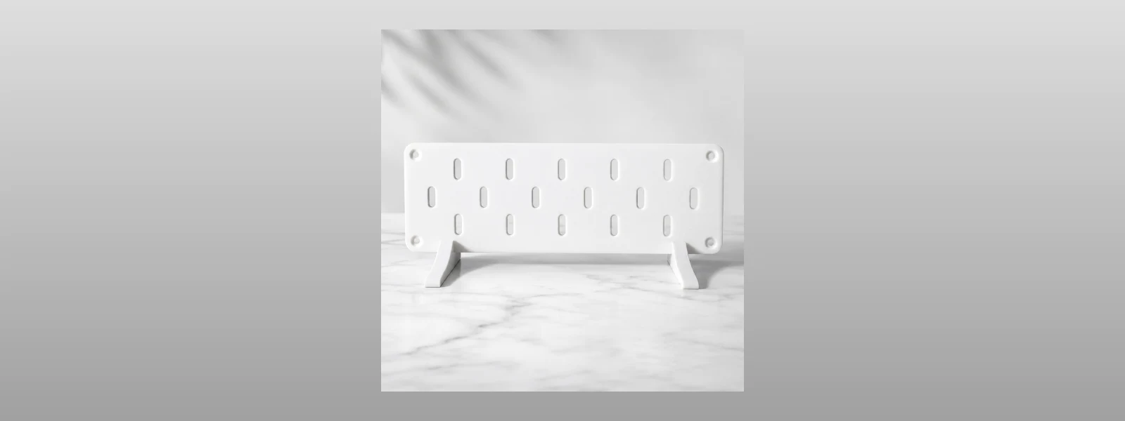 Duvara monte edilmiş delikli düzenleme panosu (pegboard) ve üzerindeki askılar