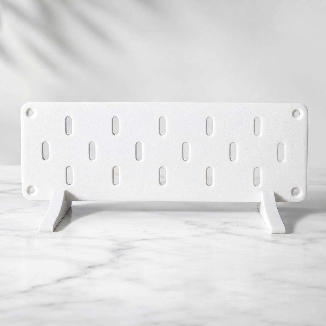 Duvara monte edilmiş delikli düzenleme panosu (pegboard) ve üzerindeki askılar