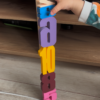 Montessori sayı bloklarını üst üste dizerek kule yapan küçük çocuk, renkli 3D baskı bloklarla oynuyor.