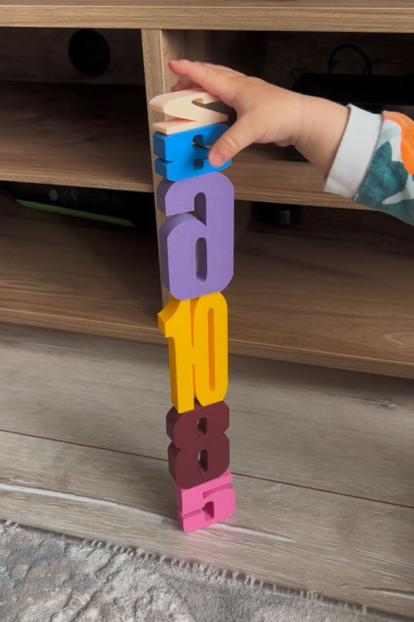 Montessori sayı bloklarını üst üste dizerek kule yapan küçük çocuk, renkli 3D baskı bloklarla oynuyor.
