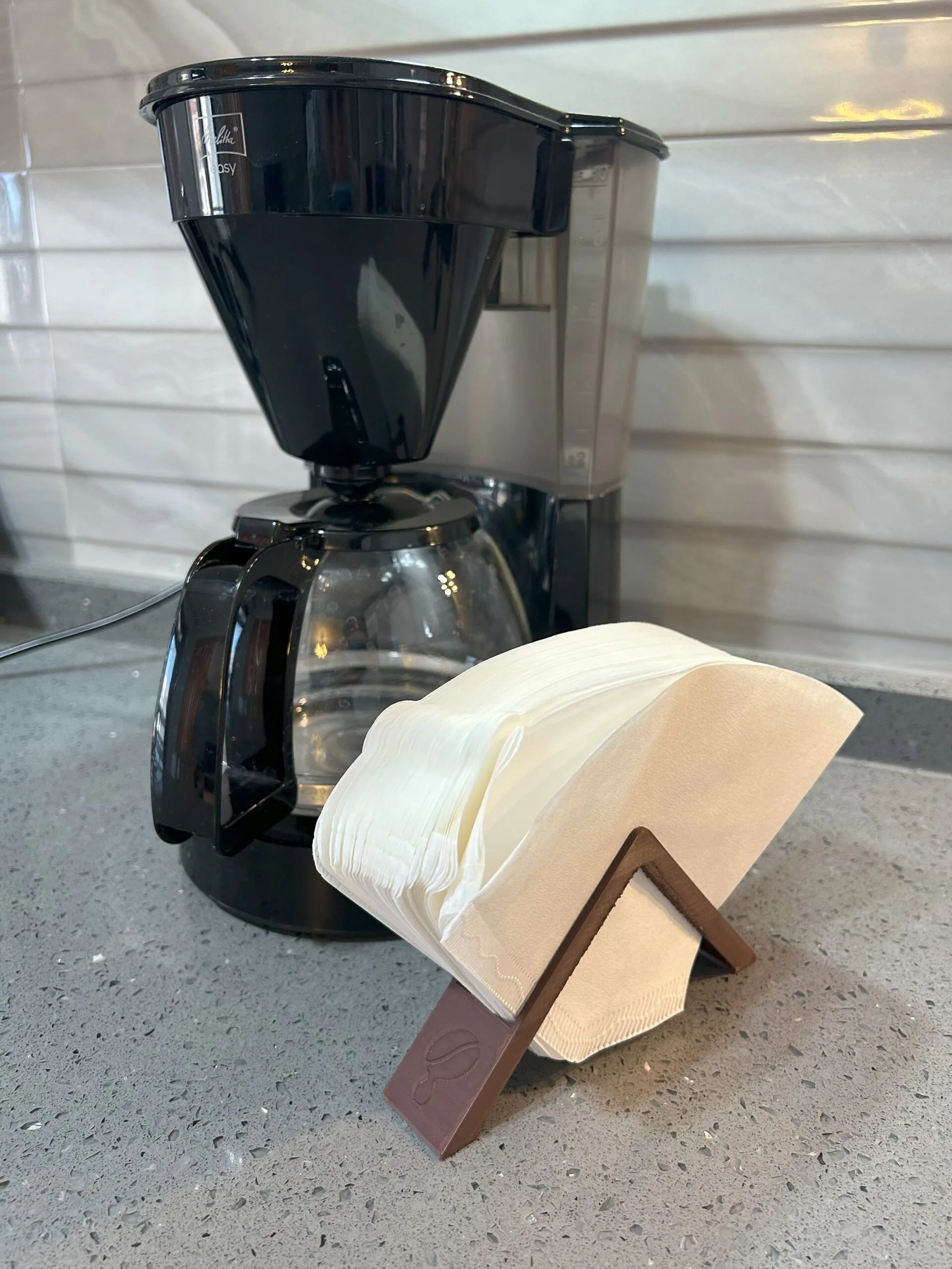 Filtre kahve makinesi önünde duran kahverengi 3D baskı filtre kahve kağıdı tutucu stand.