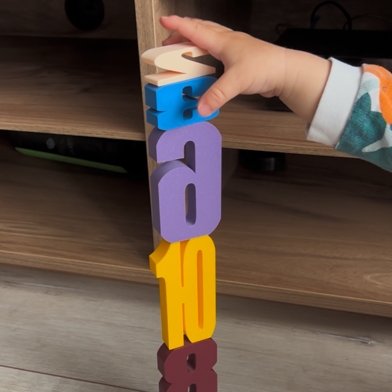Montessori sayı bloklarını üst üste dizerek kule yapan küçük çocuk, renkli 3D baskı bloklarla oynuyor.