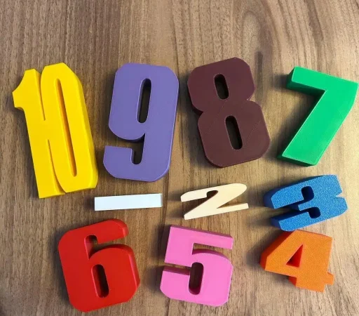 Ahşap zemin üzerinde dağınık halde duran renkli 3D baskı Montessori sayı blokları ve işlem sembolleri, okul öncesi eğitici oyuncak seti.
